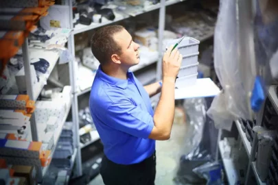 Warehouse employee using well-organized storage unit for supply overflow