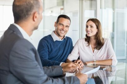 a couple sitting at a table with a business man