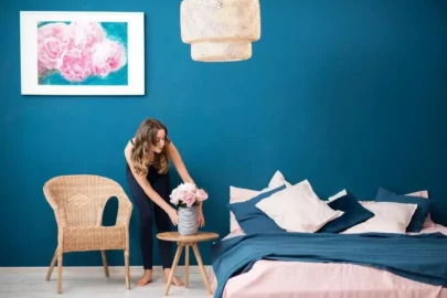 Woman decorating in blue bedroom.