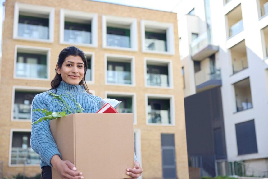 A woman moving her belongings into her college dorm. 