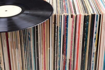 A record player disc laying on top of a shelf of record player albums.