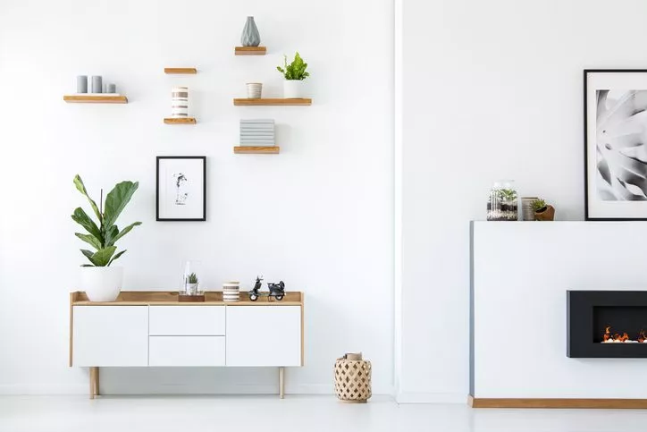 Decorations on white cabinet with fireplace in apartment. 