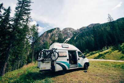 an RV parked in off the road running through a mountain
