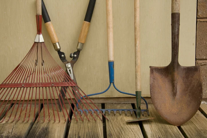 Garden tools leaned up against a wall.