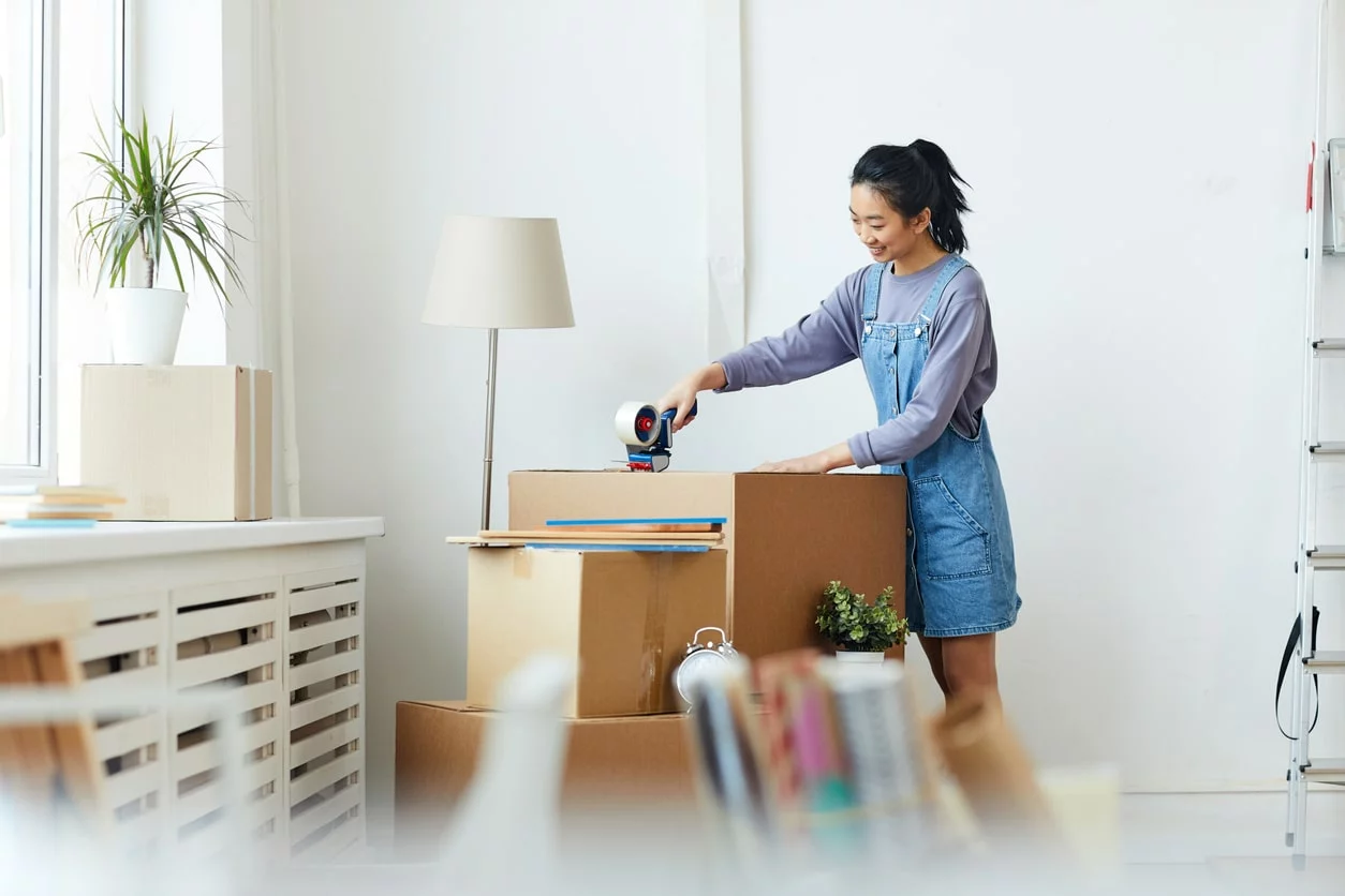 A student using boxes and tape to store items.