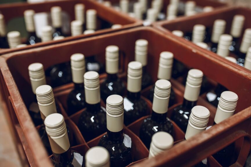 Bottles of wine standing upright in a storage crate.