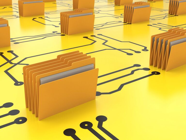 Paper files sit on an oversized yellow circuit board.