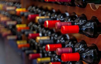 Several wine bottles stored horizontally in a wooden wine rack.