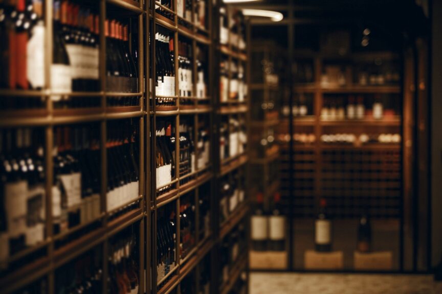 Wine bottles displayed on shelves inside a wine storage facility. 