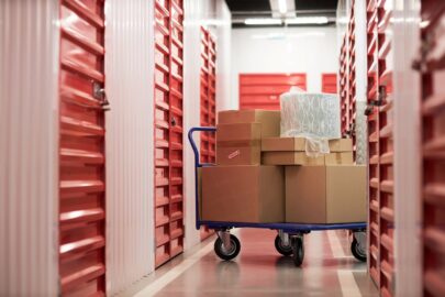 A handcart with stacked cardboard boxes in front of a storage unit