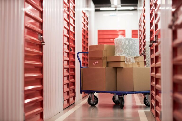 A handcart with stacked cardboard boxes in front of a storage unit